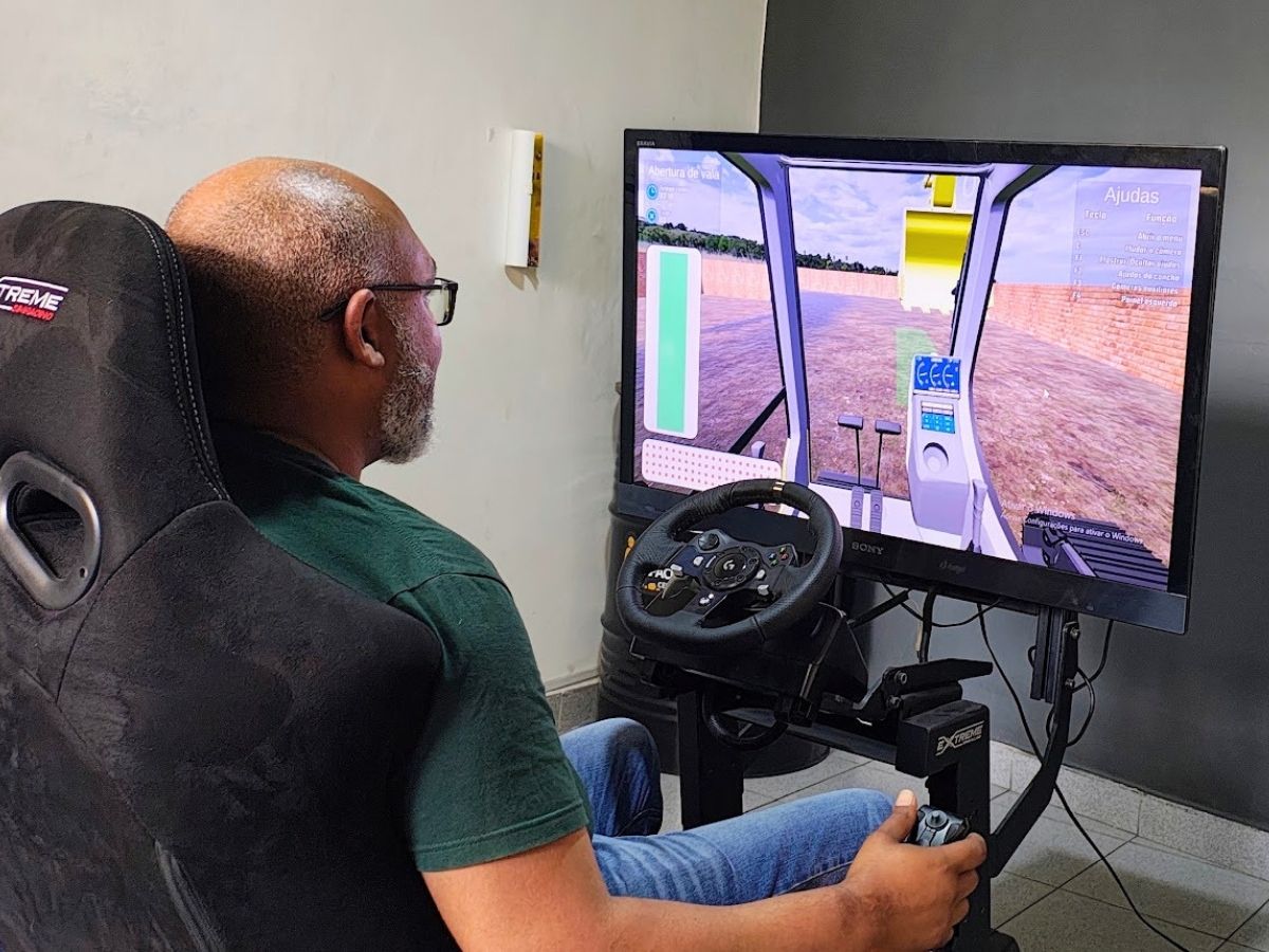 Aluno em treinamento prático em simulador de retroescavadeira de alta fidelidade - Capacitar Operadores